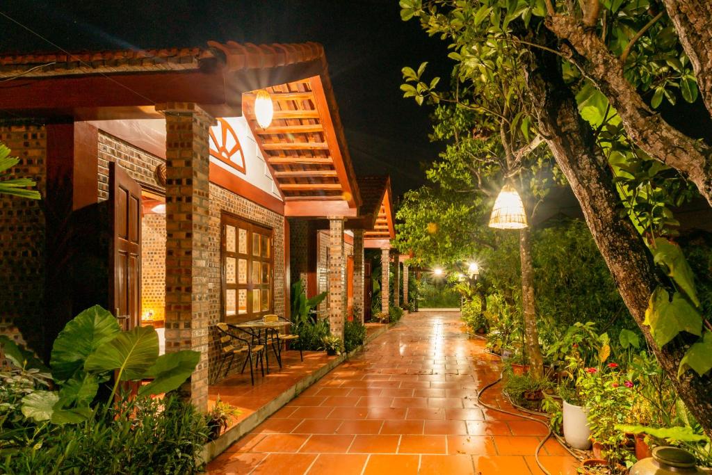 a rain soaked walkway in a garden at night at Bai Dinh Eco Homestay in Ninh Binh