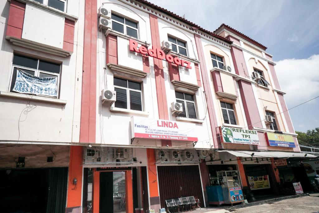 a pink and white building with a sign on it at RedDoorz near Palembang Square Mall 2 in Palembang