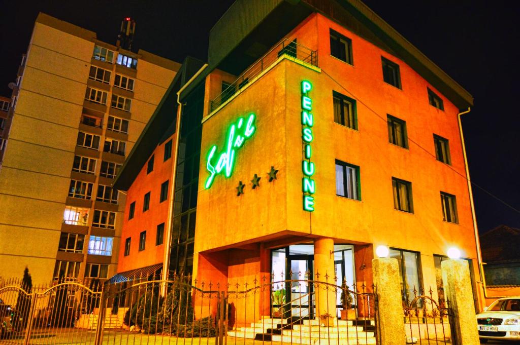 a building with a neon sign on the side of it at Pension Sofie in Braşov