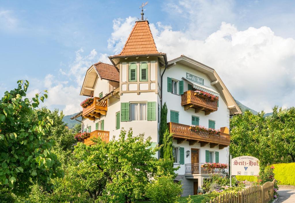 een hoog wit gebouw met een torentje bij Gästehaus Seitzhof in Merano