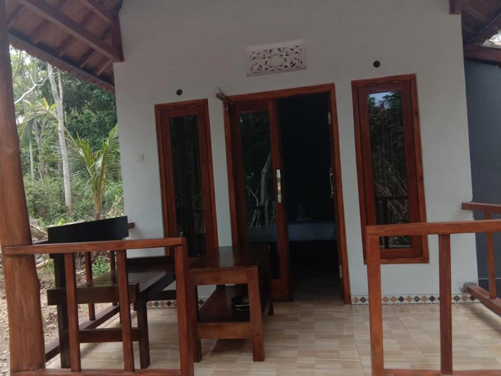 a room with wooden tables and chairs in a house at Caga Garden in Nusa Penida