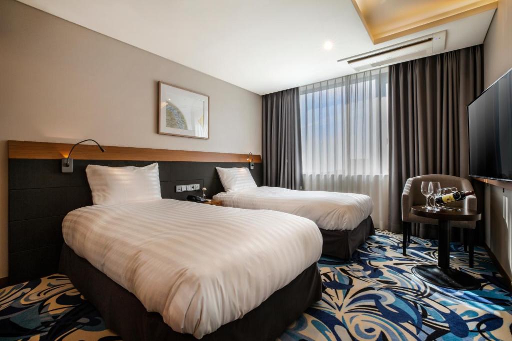 Postel nebo postele na pokoji v ubytování Shin Shin Hotel Jeju Airport