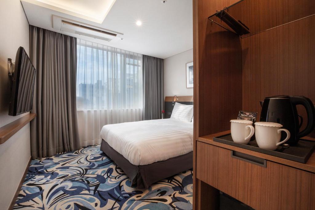 Postel nebo postele na pokoji v ubytování Shin Shin Hotel Jeju Airport