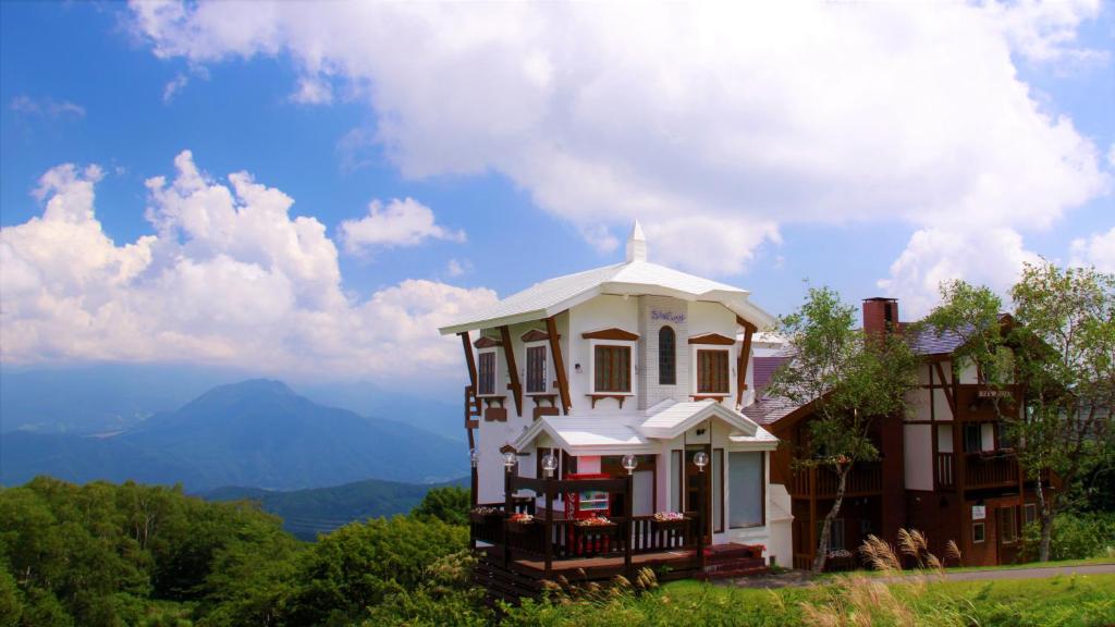 a house on top of a hill with a view at Blueberry Pension Madarao in Iiyama