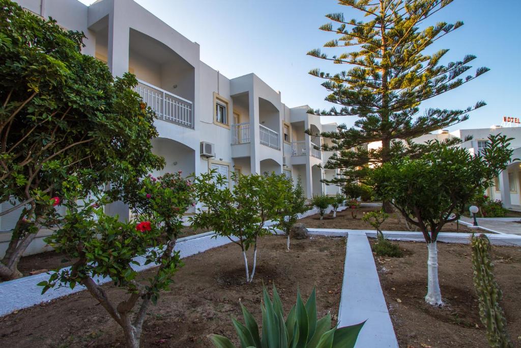 Blick auf die Außenseite eines Gebäudes mit Bäumen in der Unterkunft Irene Hotel Leros in Alinda