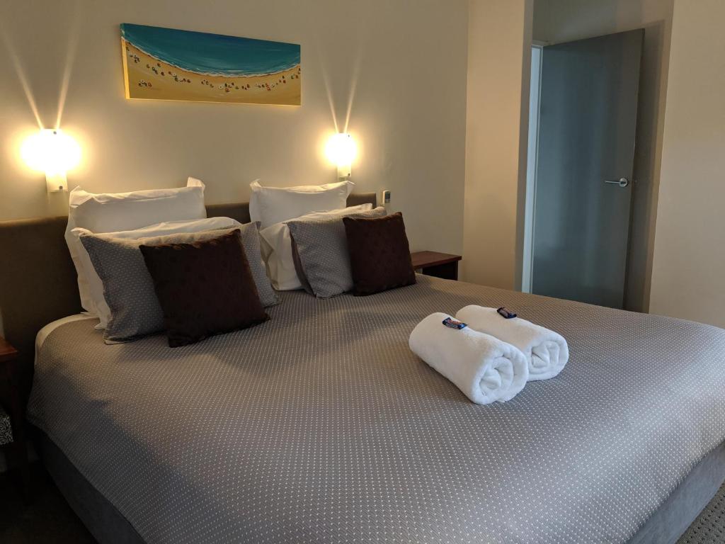um quarto com uma cama com toalhas em Hanover Bay Apartments em Albany