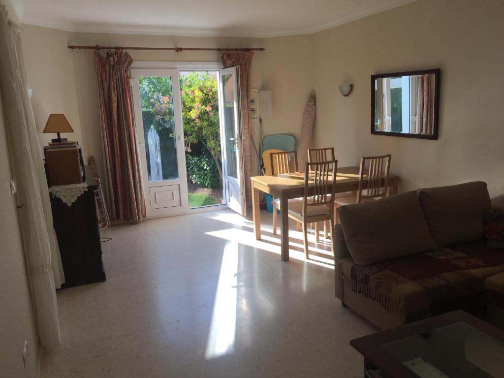 un salon avec un canapé, une table et des chaises dans l'établissement House with garden at Oliva Nova MET & Golf & Padel & Beach resort, à Casas Devesa