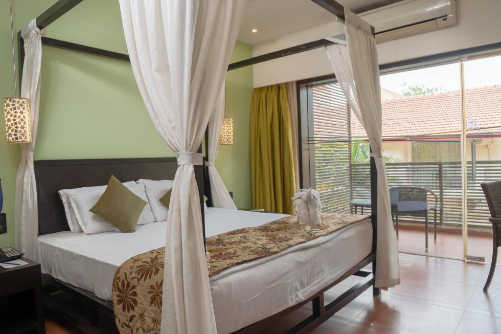 Postel nebo postele na pokoji v ubytování Kyriad Prestige Calangute Goa by OTHPL