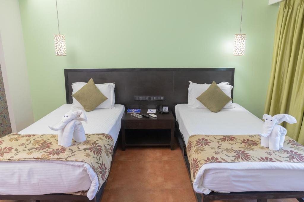 Postel nebo postele na pokoji v ubytování Kyriad Prestige Calangute Goa by OTHPL
