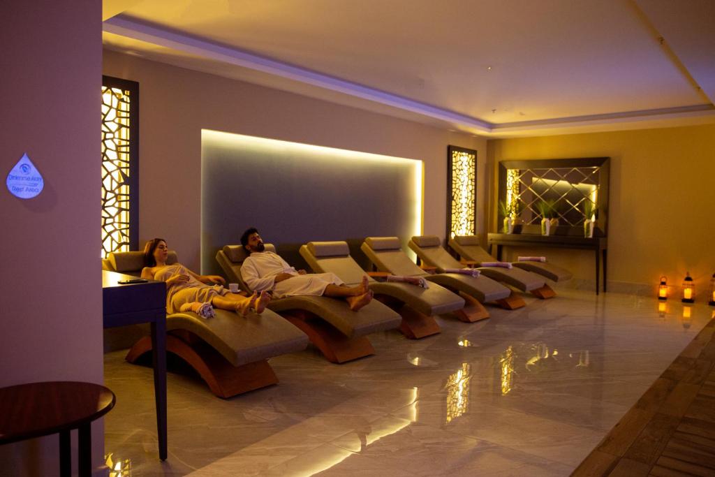 two people sitting on a couch in a living room at Premier Vista Hotel in Silivri