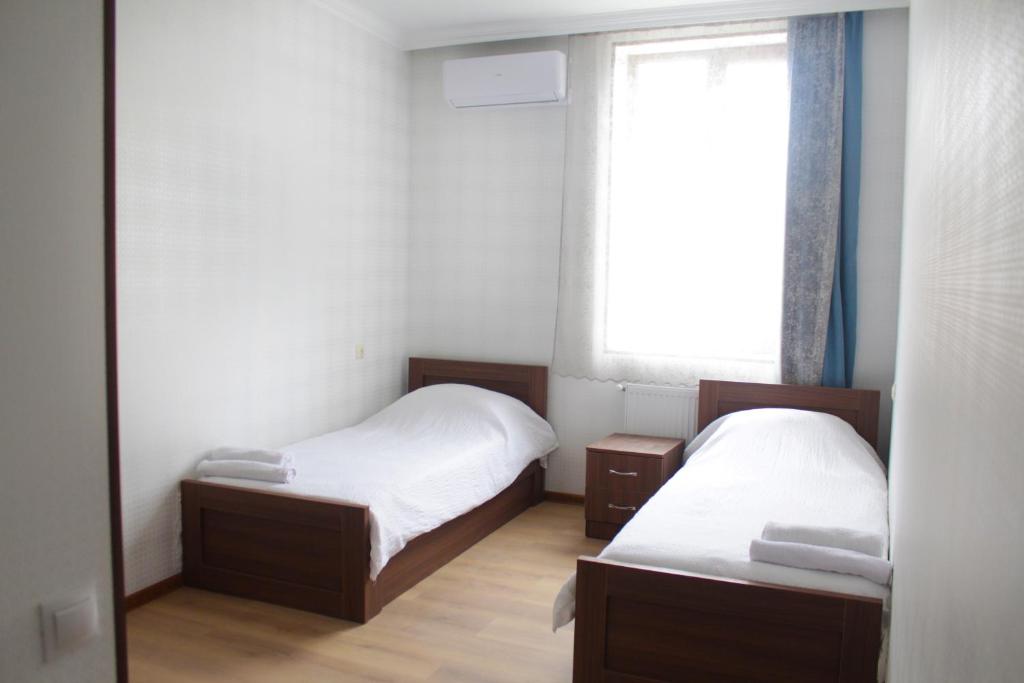 a small room with two beds and a window at Bagration in Gori