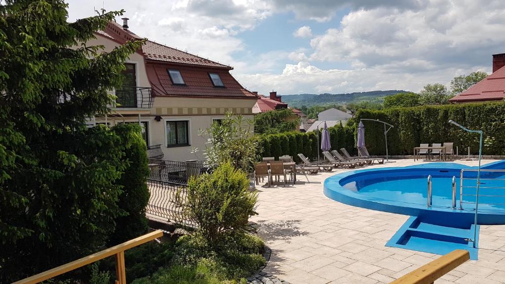 un patio con piscina y una casa en Janda Resort & Conference, en Mszana Dolna