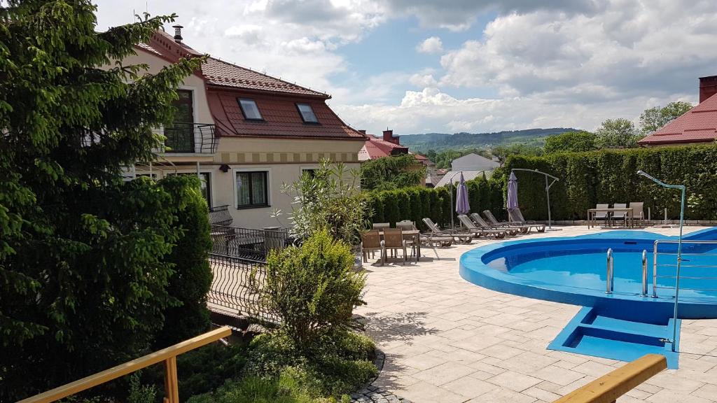 a patio with a swimming pool and a house at Janda Resort & Conference in Mszana Dolna