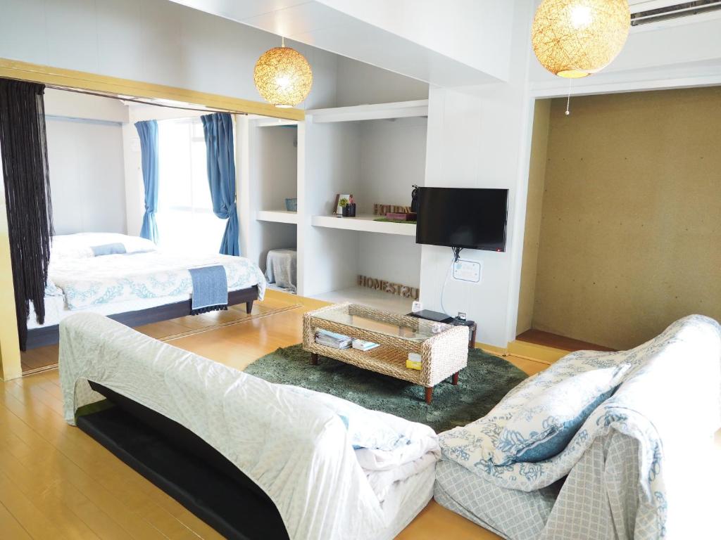 a living room with a couch and a tv at Holiday Homes TSUBOYA 505 in Naha