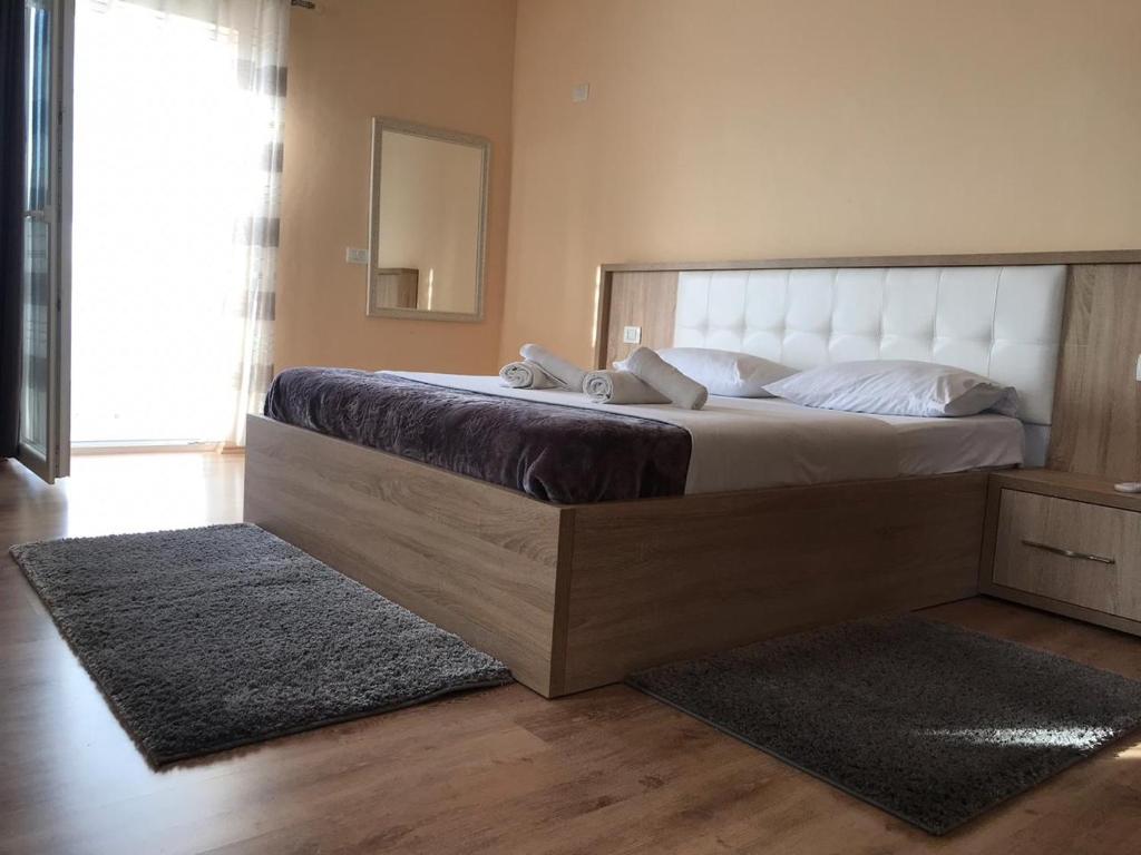 a bedroom with a large bed and a mirror at Hotel Floga in Shkodër