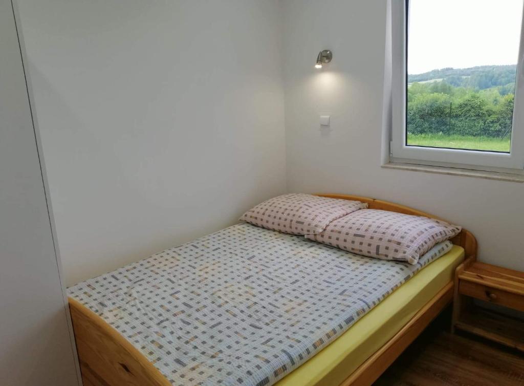 Cama pequeña en habitación con ventana en Bieszczadzki Orzeł en Berezka