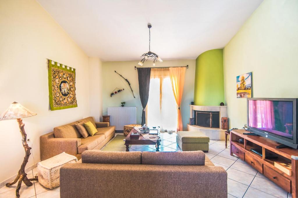 a living room with a couch and a tv at "Alkinoi" apartment in Kastanéa