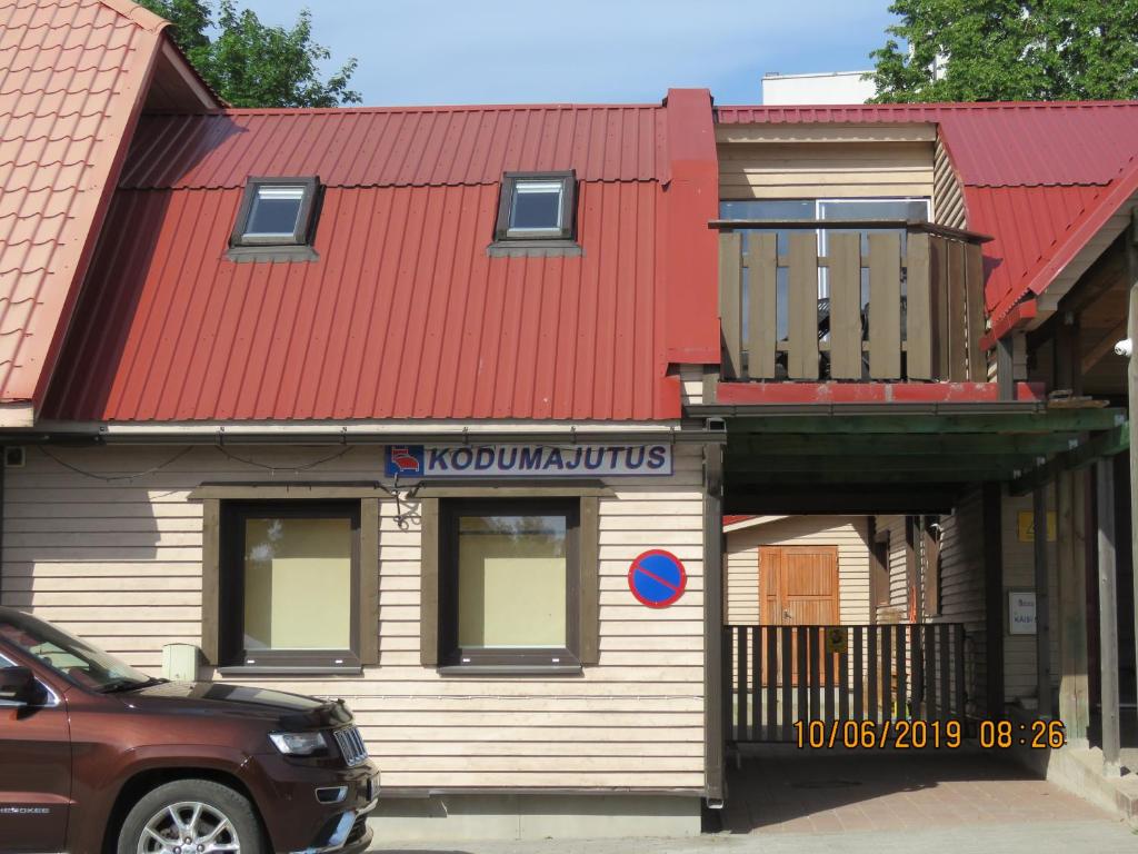 un edificio con techo rojo y balcón en Urmas Rehvid Holiday Home en Põlva