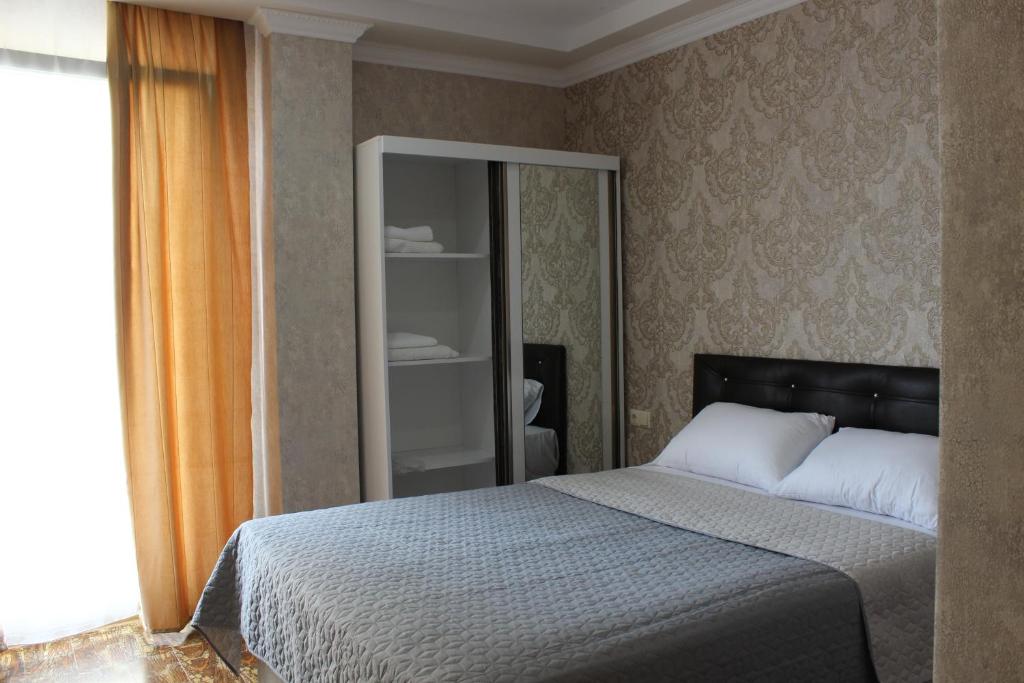 a bedroom with a bed and a large mirror at UNION in Batumi