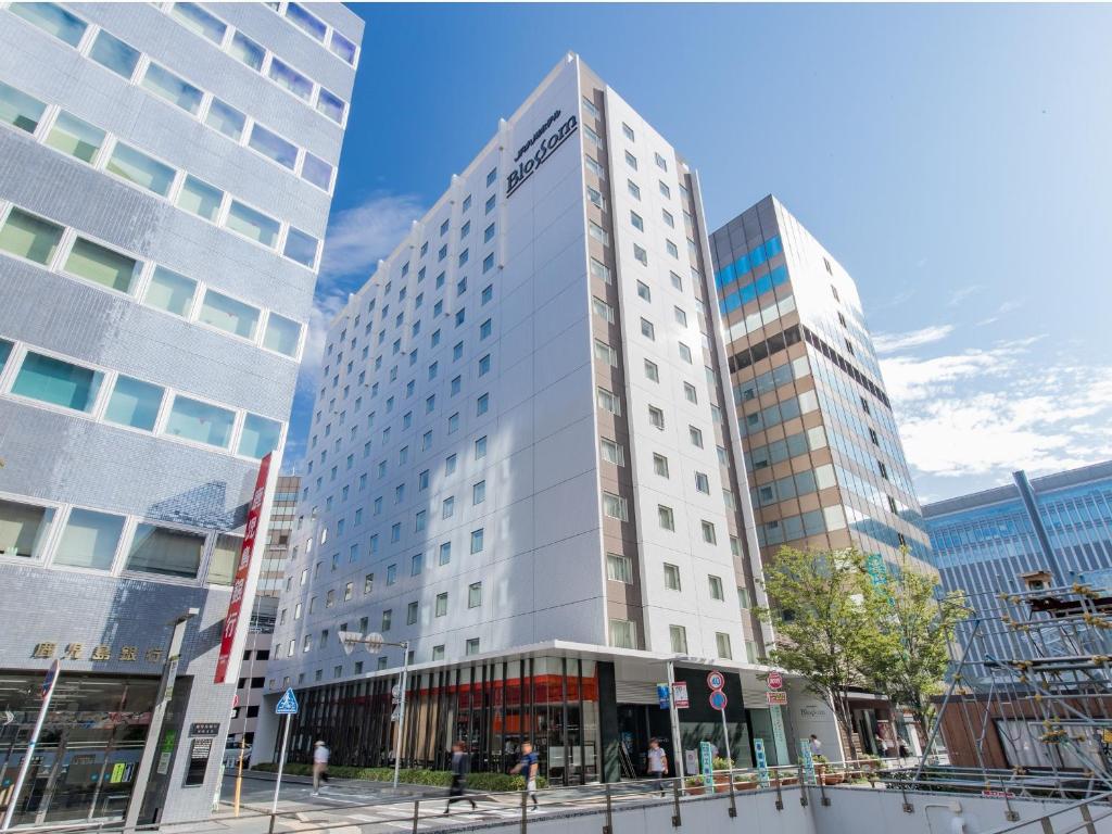 福岡市にあるJR 九州ホテル ブラッサム博多中央の高い白い高い建物が2棟