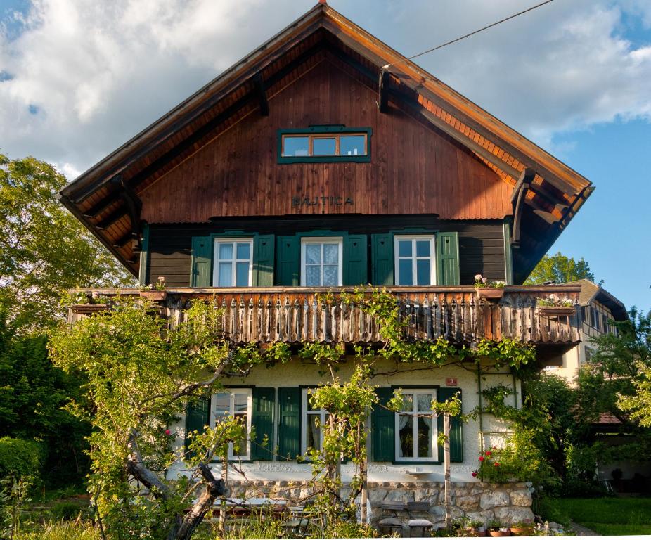 ein Holzhaus mit Balkon darüber in der Unterkunft Bajtica Guesthouse in Bled