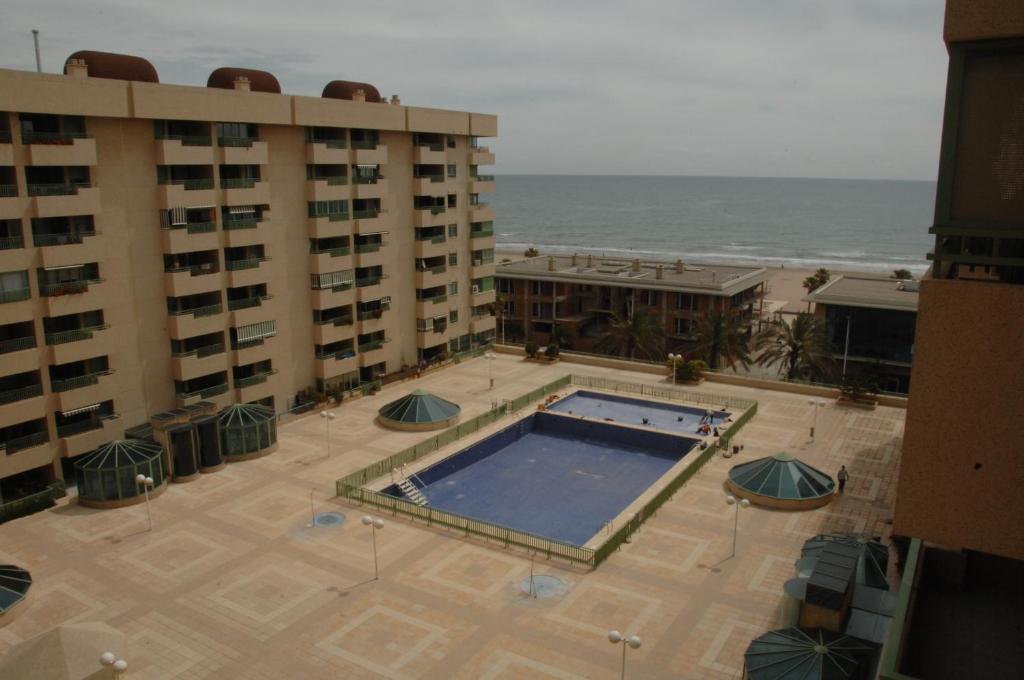vistas a una piscina frente a algunos edificios en Accommodation Beach Apartments, en Valencia