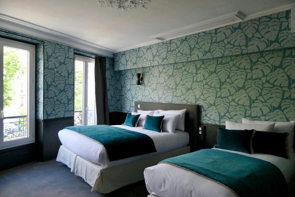 um quarto com 2 camas em verde e branco em Hôtel Avama Prony em Paris