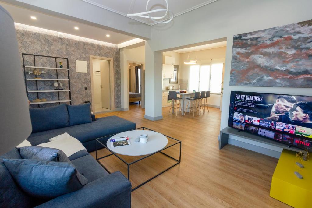 un soggiorno con divano blu e TV di Heraklion chic and minimalistic apartment with sea view a Heraklion