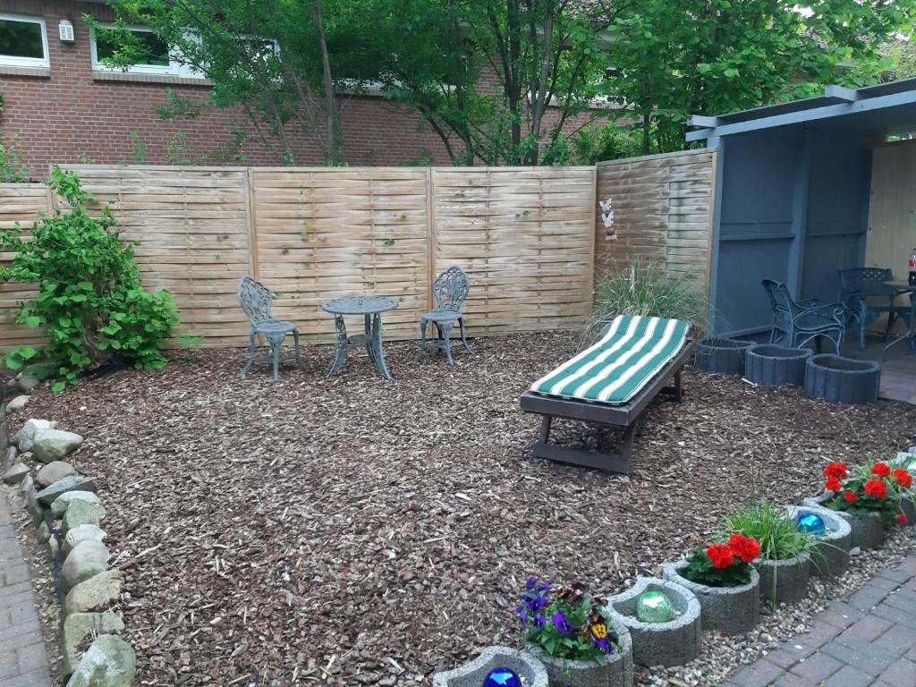 a garden with a bench and chairs and a table at Nicki's Ferien Oase in Bornhöved