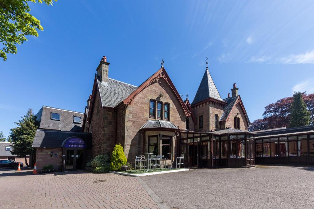 a large brick building on a street at Craigmonie Hotel Inverness by Compass Hospitality in Inverness