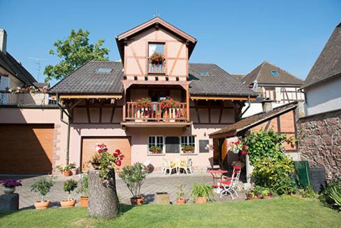 een groot huis met een balkon en een patio bij Chez René in Ammerschwihr