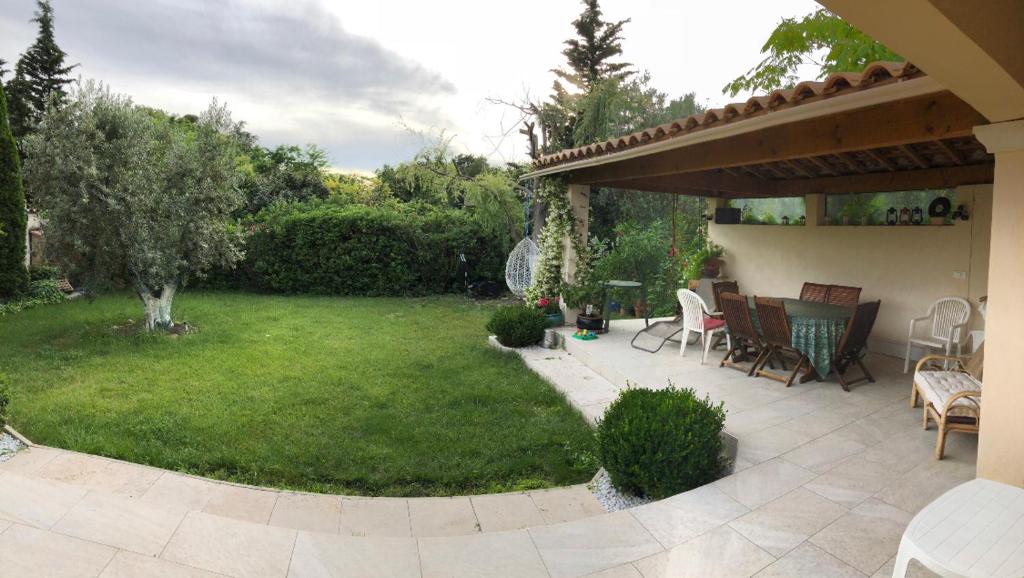 une cour avec une terrasse et une pelouse avec des chaises dans l'établissement Domaine du Castel, à Aix-en-Provence