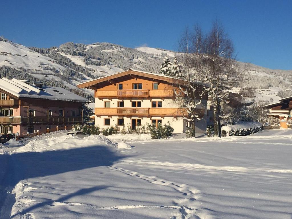 a building in the snow with footprints in the snow at Appartementhaus Schubert in Westendorf