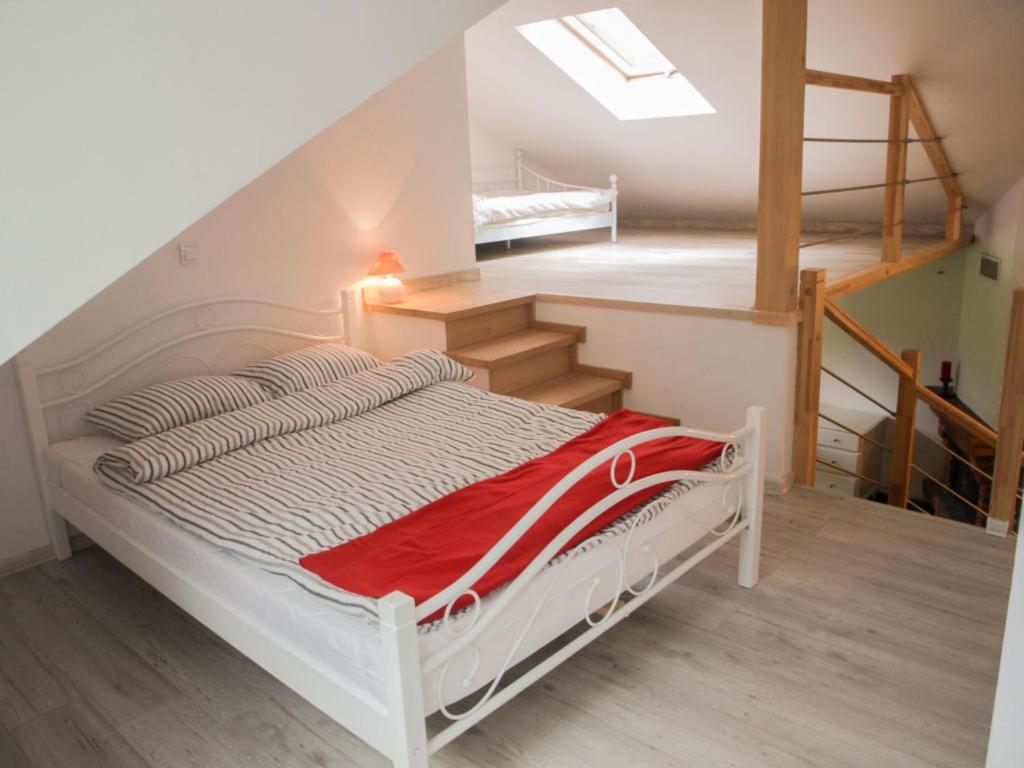 a white bed in a room with a staircase at Pod Klonem in Szczawnica