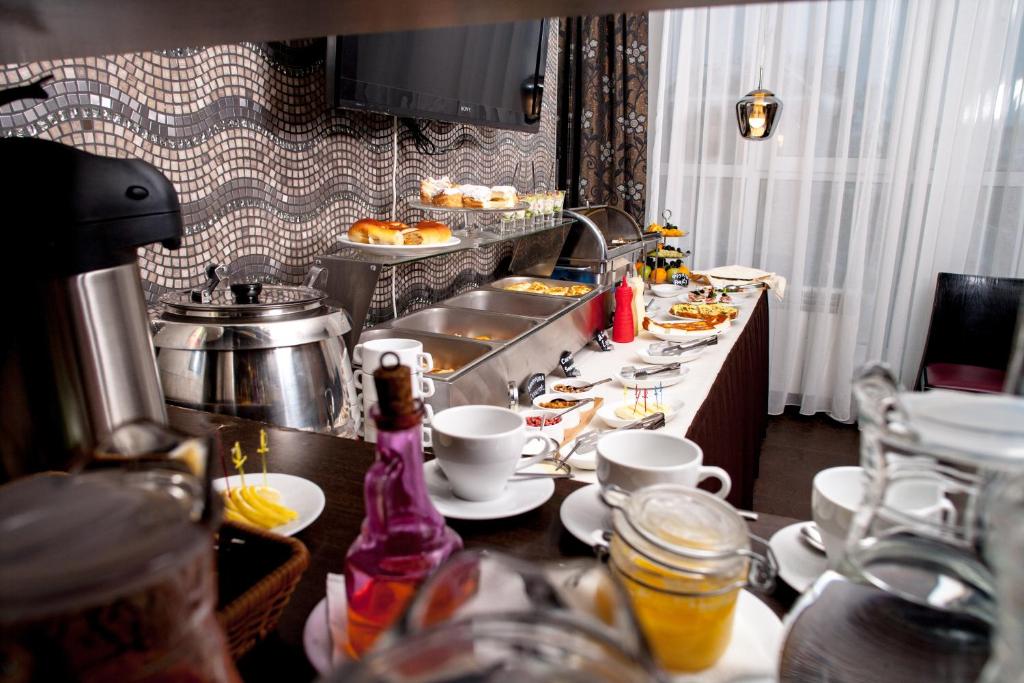 a kitchen with a table with plates of food at Business Hotel Diplomat in Nizhny Novgorod