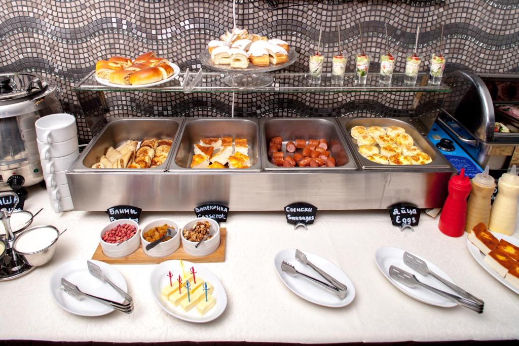a table with plates and trays of food at Business Hotel Diplomat in Nizhny Novgorod