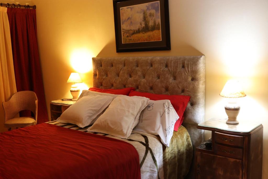 sypialnia z łóżkiem z czerwoną pościelą i białymi poduszkami w obiekcie Casa Alberdi w Córdobie