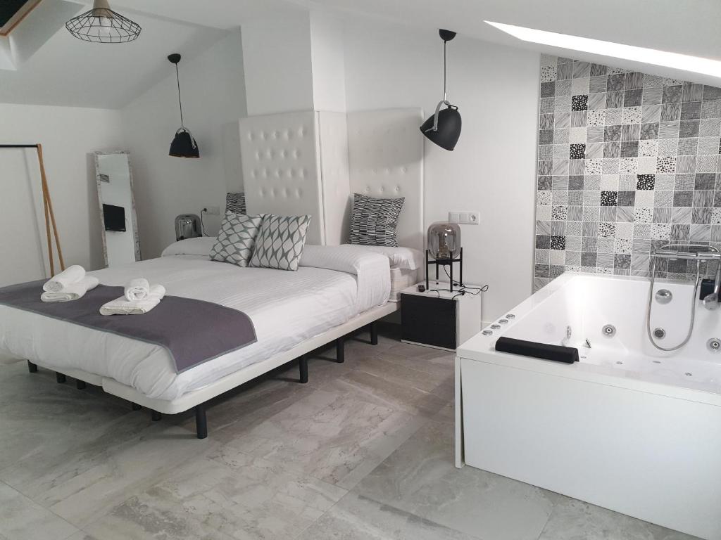 - une chambre avec un lit et une baignoire dans l'établissement Apartamentos Hostal Cabañas, à Carboneras de Guadazaón