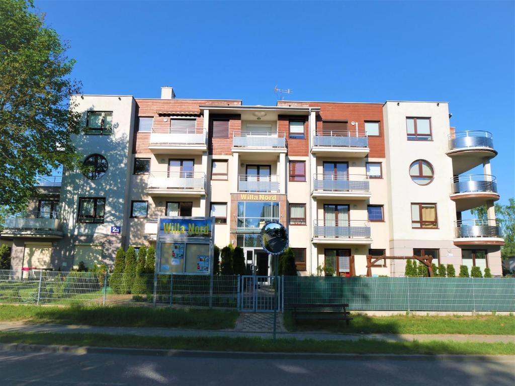 a large building with a fence in front of it at Apartament Kaszubski in Jastrzębia Góra