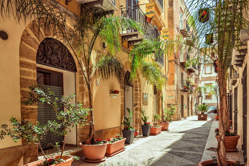 un callejón en un viejo pueblo con macetas en Garibaldi Relais, en Sciacca