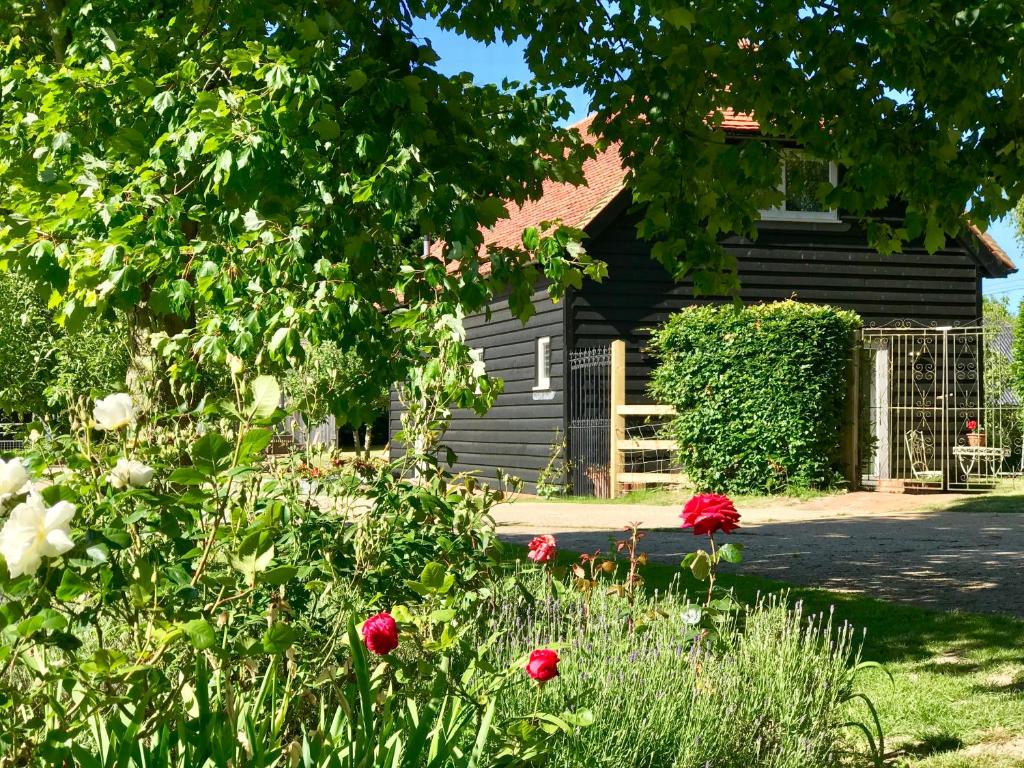a garden with flowers in front of a house at Potts Farm in Tenterden