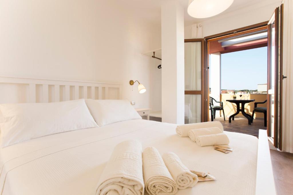 a bedroom with a white bed with towels on it at Sand'Ana House B&b in Alghero