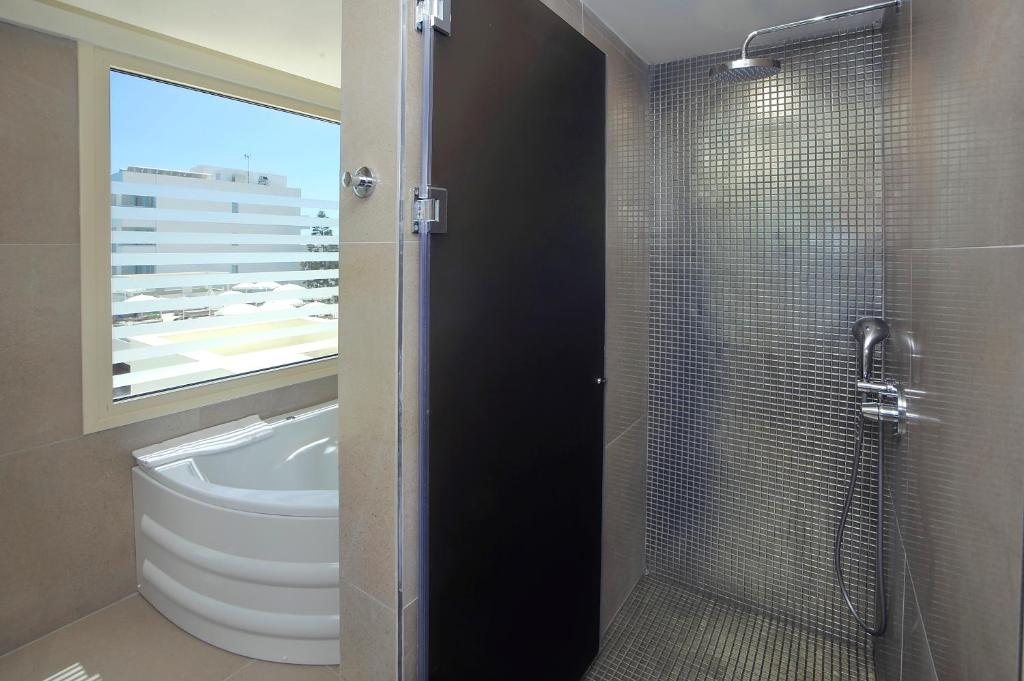 a bathroom with a shower with a toilet and a sink at Nelia Beach Hotel & Spa in Ayia Napa