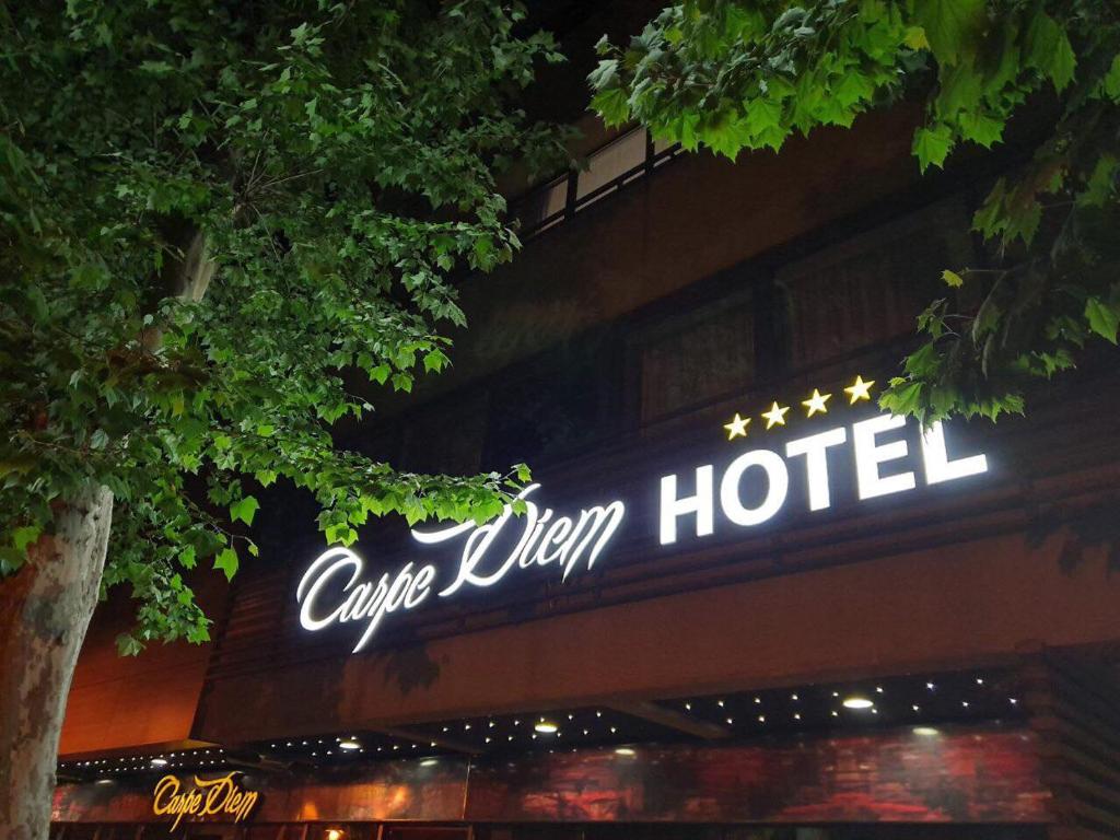 una señal para un hotel al lado de un edificio en Carpe Diem Boutique Hotel, en Zenica