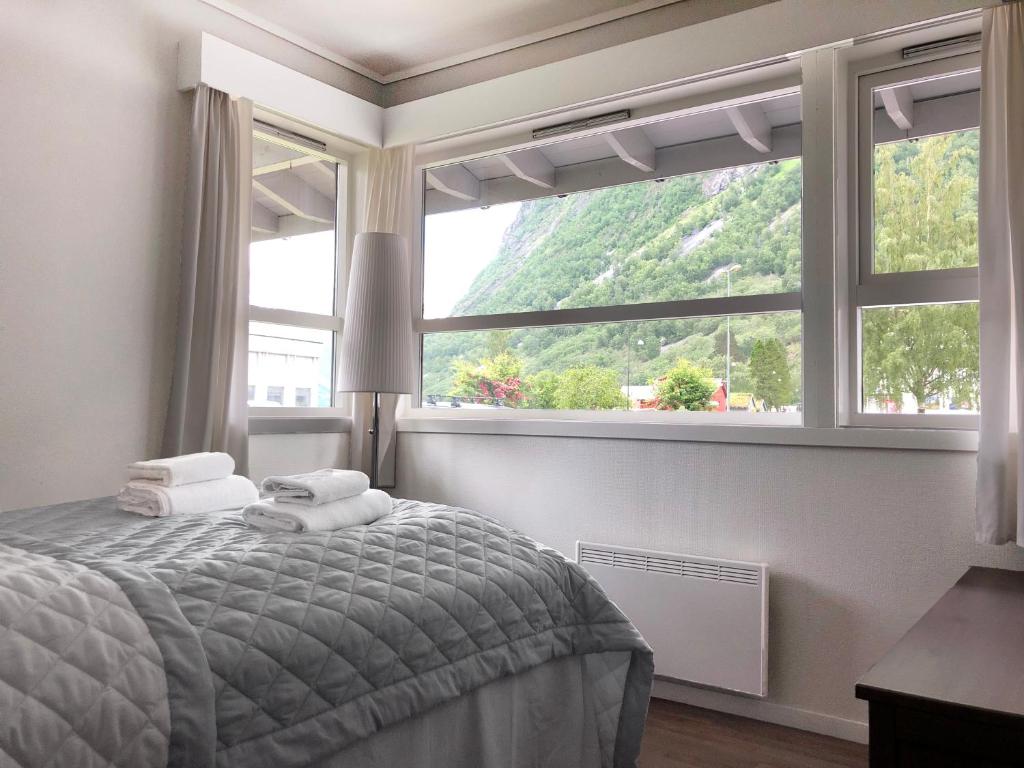 a bedroom with a bed and a large window at Norway Holiday Apartments - Norddalstunet in Norddal