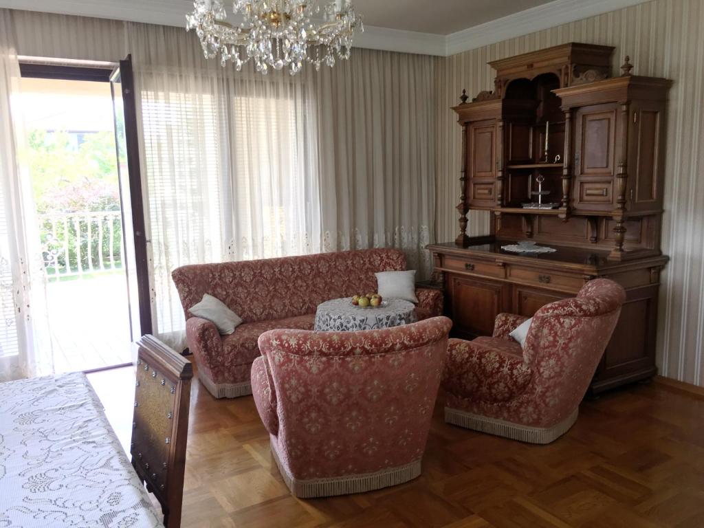 a living room with a couch and chairs and a chandelier at Zeitreise-Ferienhaus in Baden