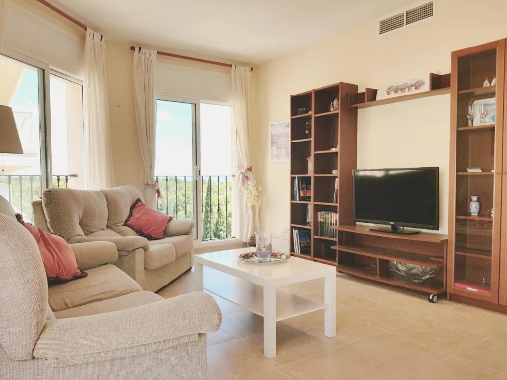 a living room with a couch and a tv and a table at Apartamento exterior en La Ametlla de Mar in L'Ametlla de Mar