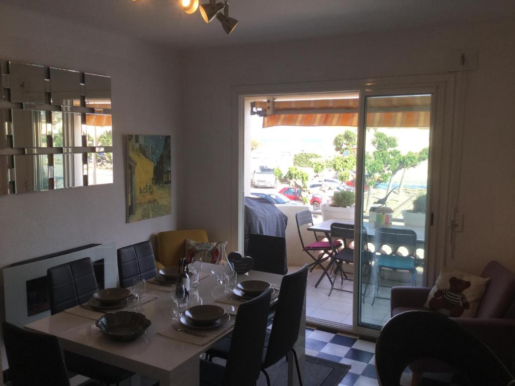 comedor con mesa y vistas a un patio en Villa Magaly T4 à 50 m de la plage de Valras centre, en Valras-Plage