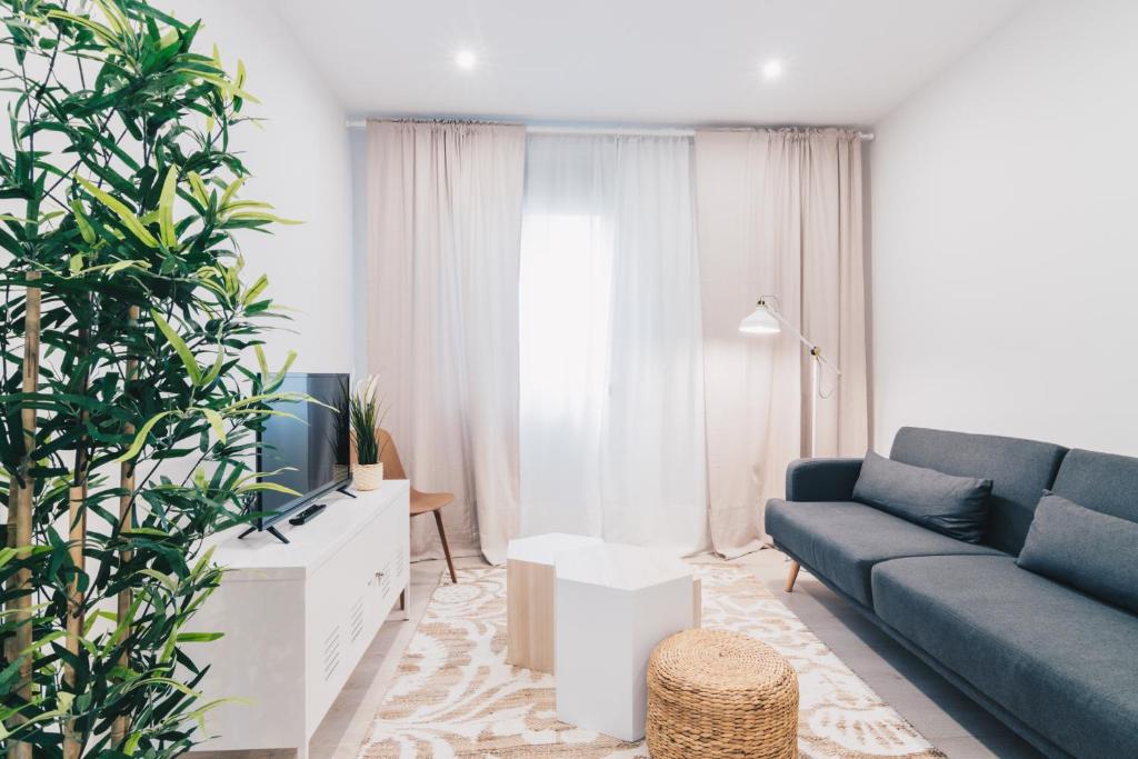 ein Wohnzimmer mit einem Sofa und einem TV in der Unterkunft Altair apartment by People Rentals in Bilbao