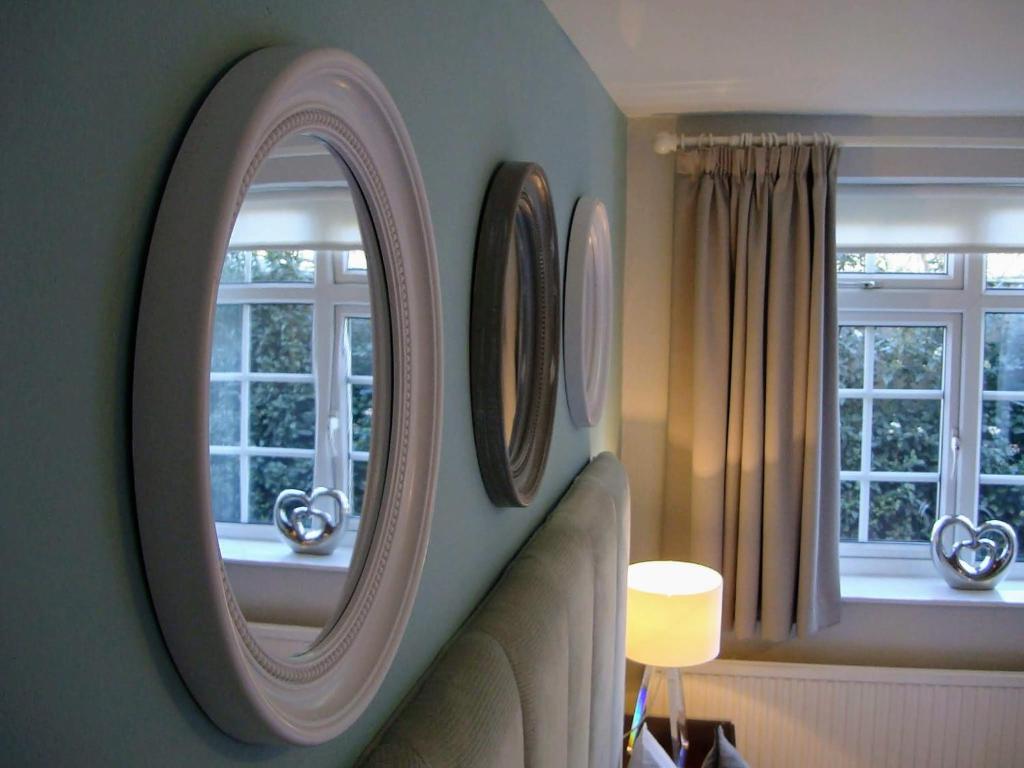 Habitación con 2 espejos redondos en la pared en Pinfield Boutique Hotel en Slough